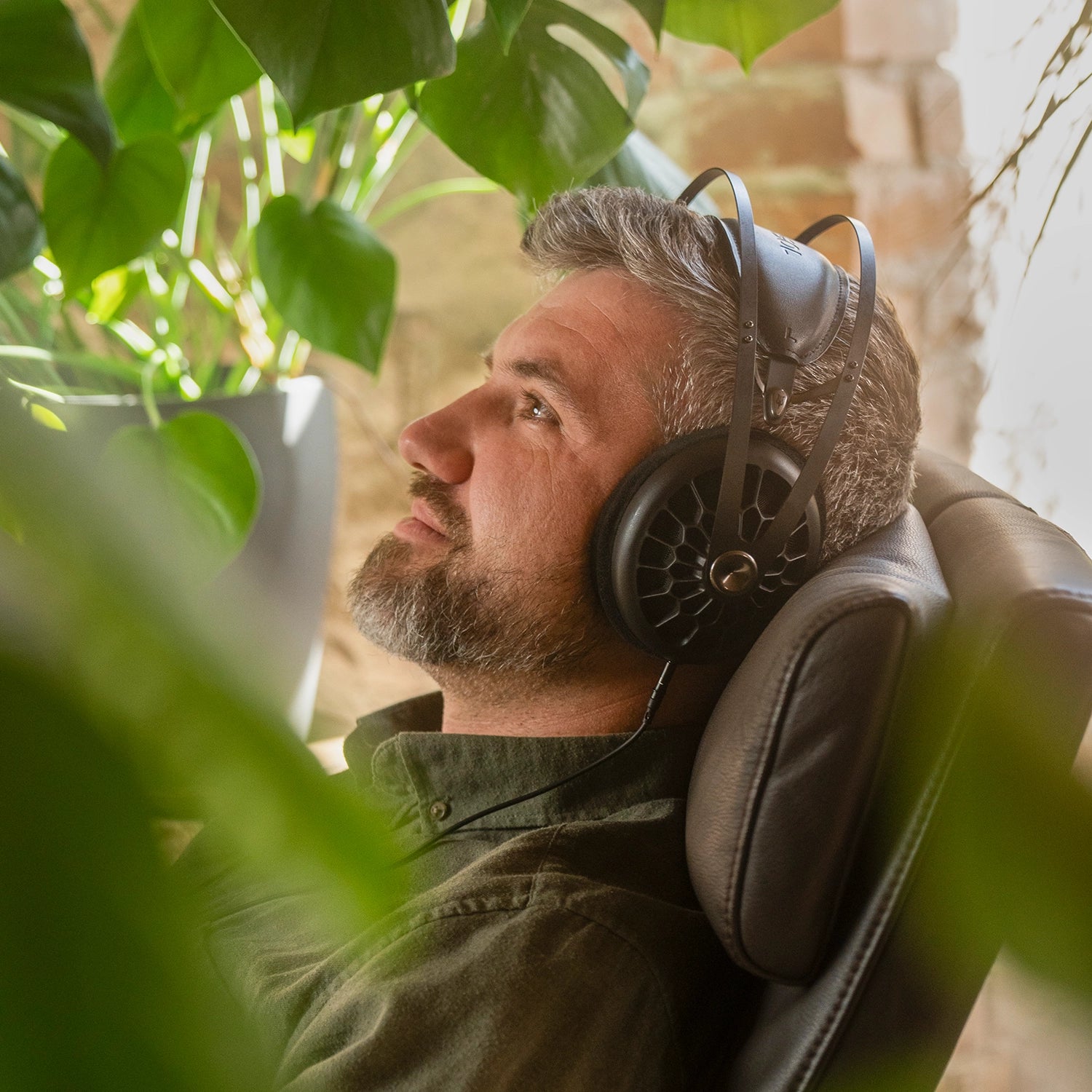 Meze Audio 105 AER best open back hifi audiophile premium headphones worn by man inside while sitting on an armchair