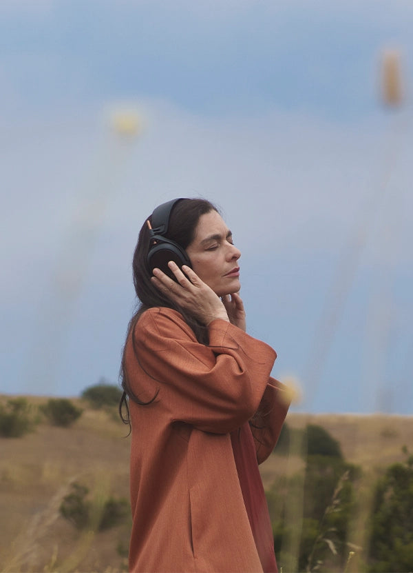 Woman listening to Meze Audio Liric premium closed back planar magnetic headphones