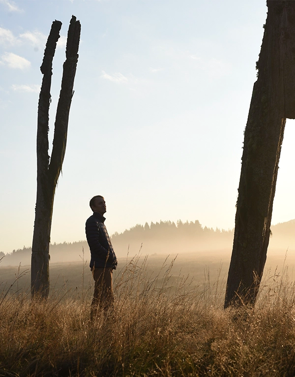 Antonio Meze in an open field with dead trees