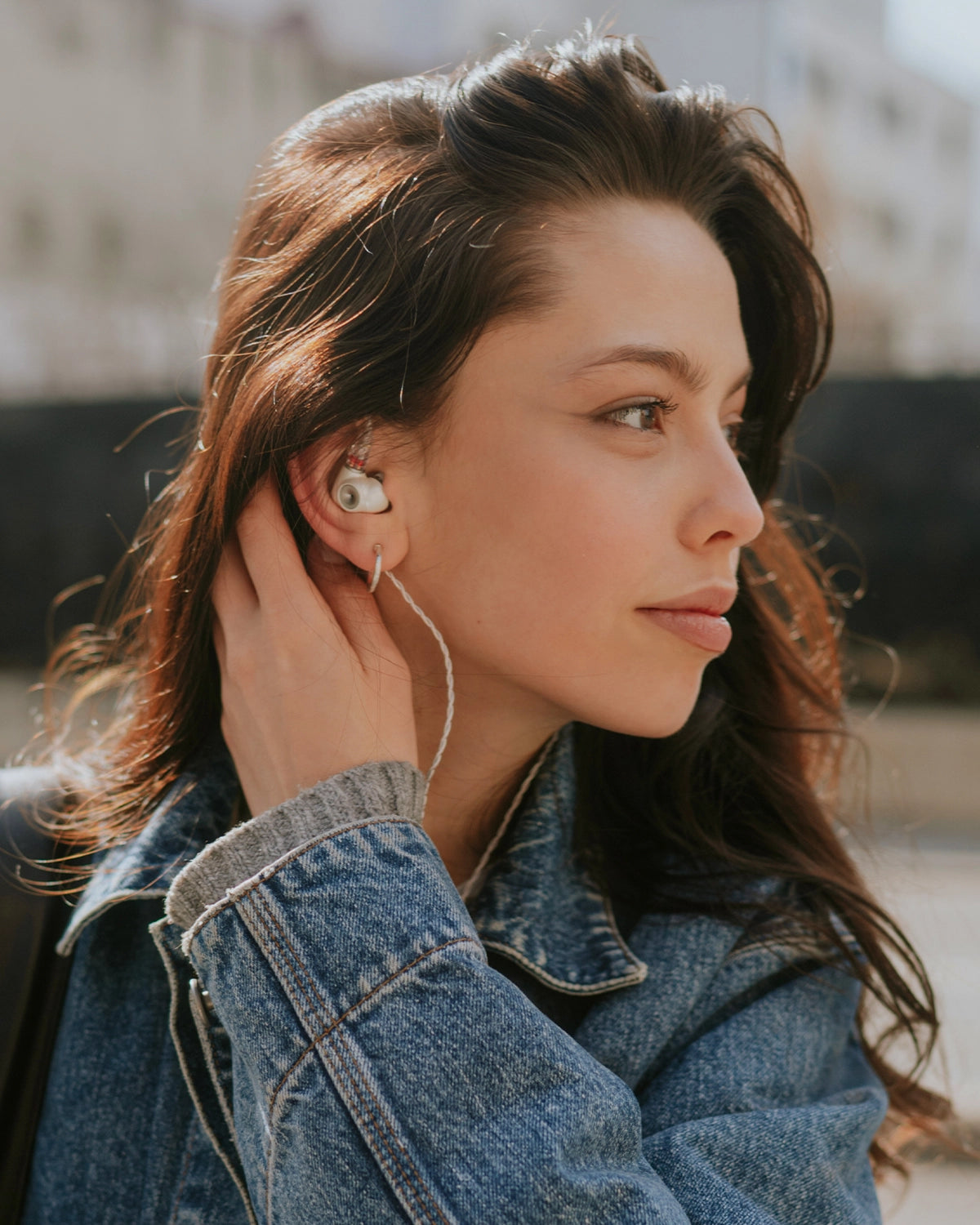 Young woman listening to Meze Audio premium IEM ALBA outdoors