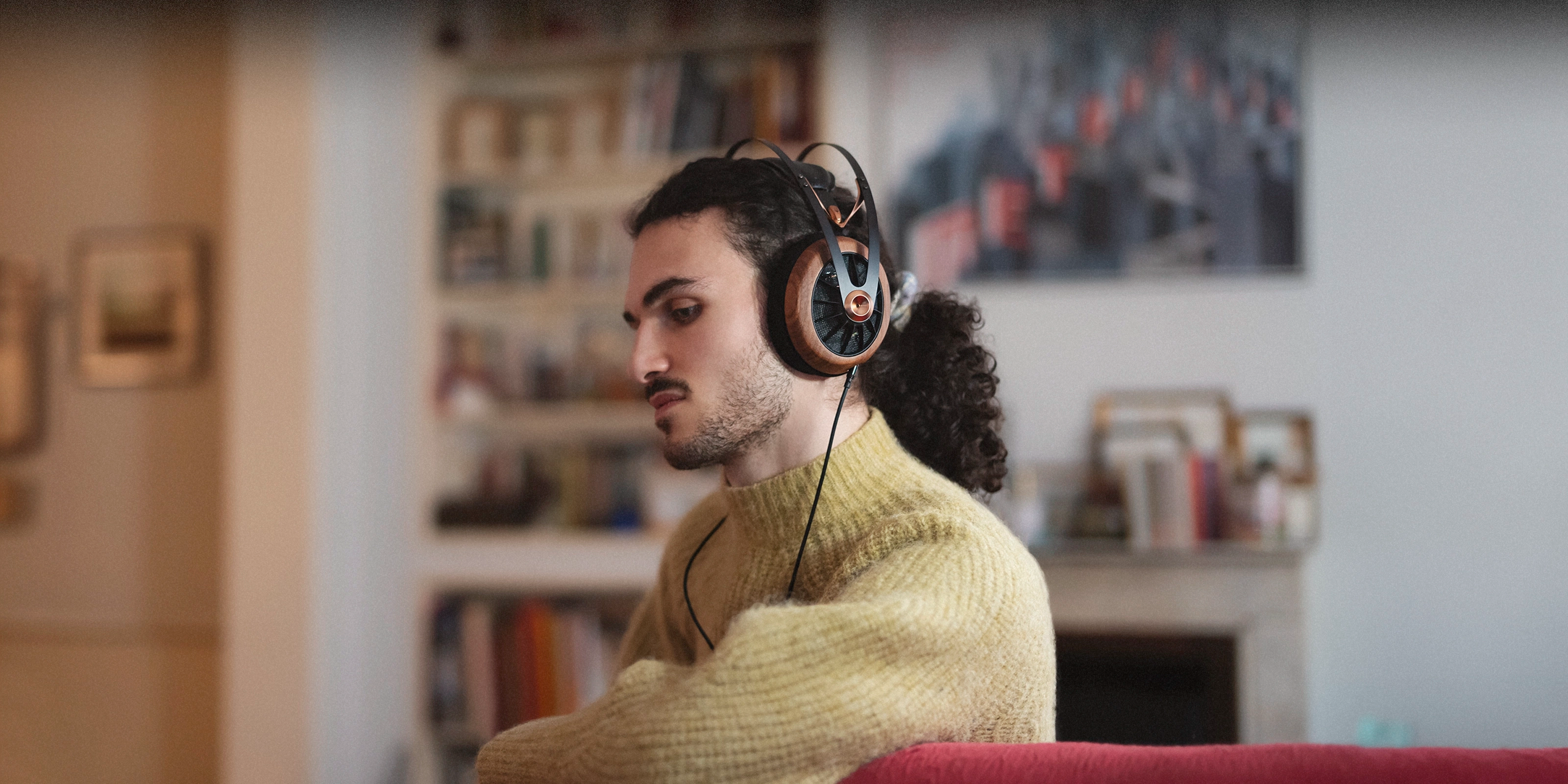 Meze Audio 109 PRO best open back audiophile headphones worn by a man with long hair inside the house