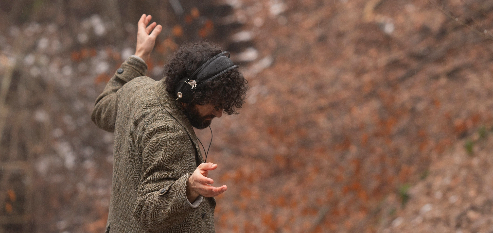 Man strolling through forest and dancing while listening to the Meze Audio 99 NEO dynamic driver closed back premium audiophile headphones