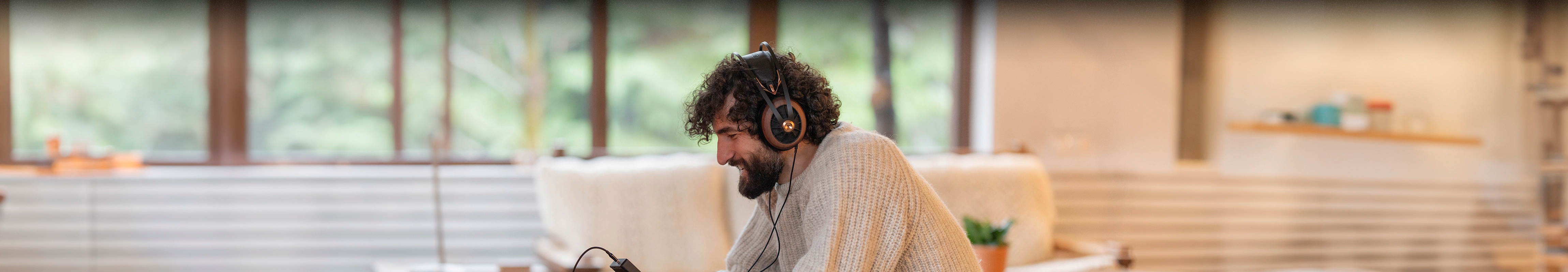 Man listening to music using the Meze Audio 109 PROI open back audiophile headphones inside his home