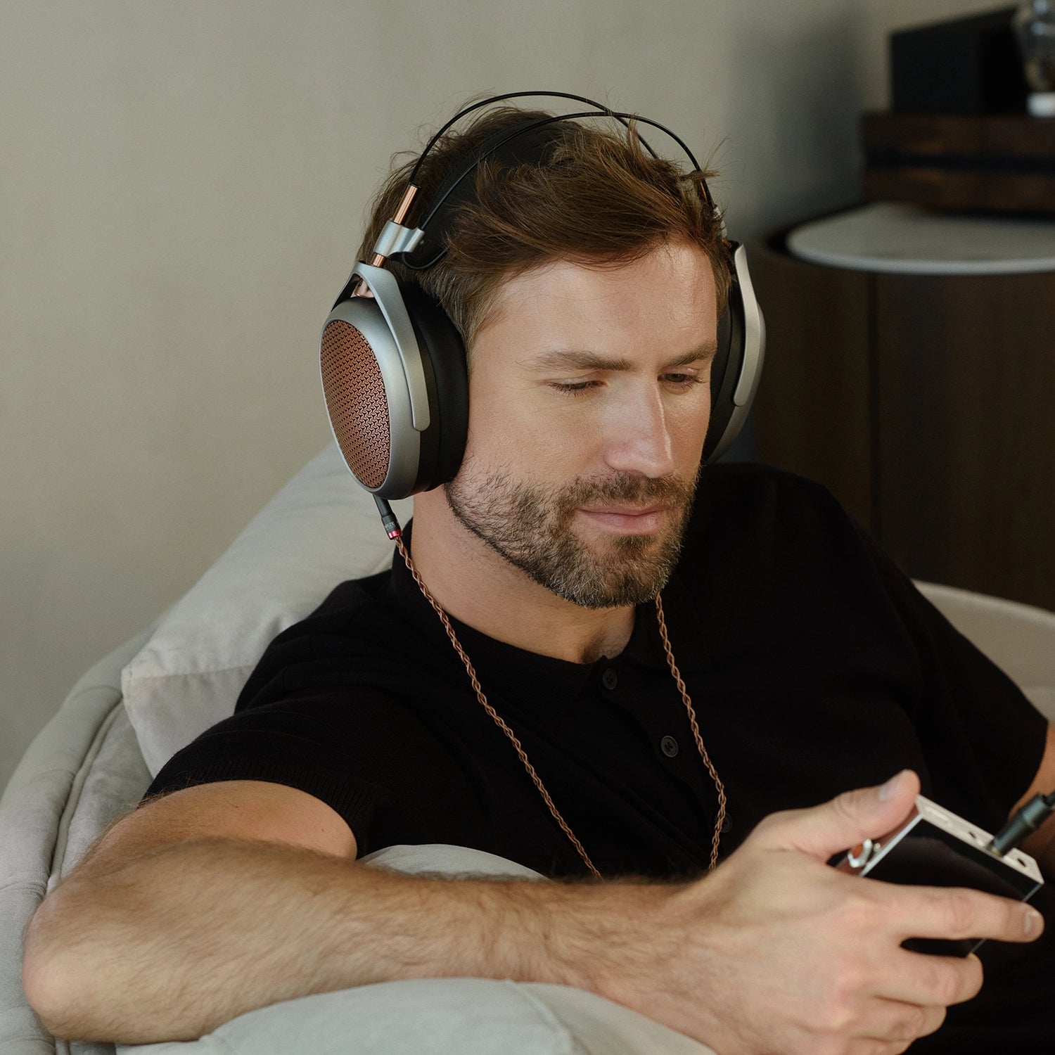 Man listening to Meze Audio premium open back planar magnetic driver headphones POET with amp indoors