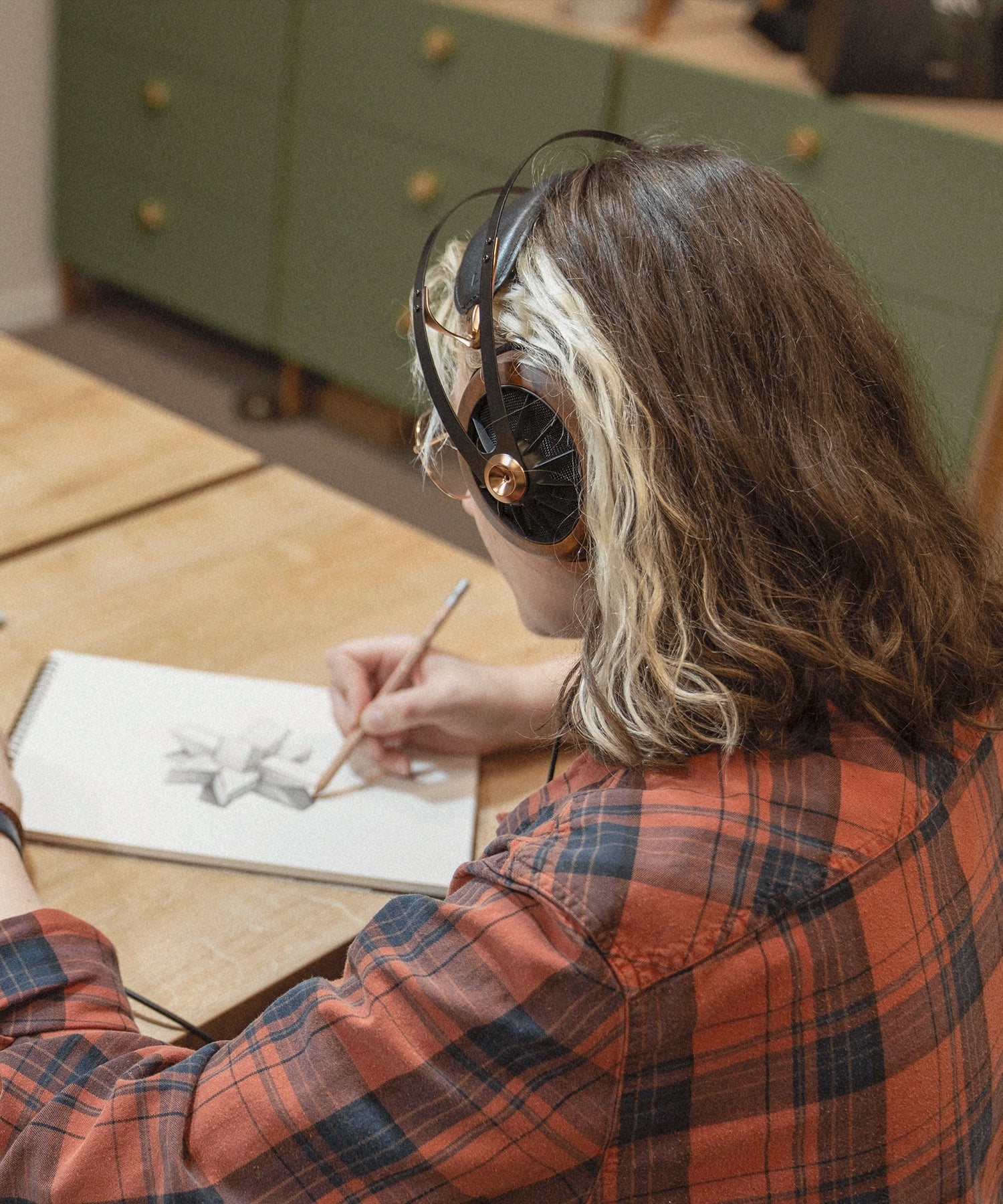 Tina drawing and using her pair of Meze Audio 109 PRO audiophile premium open back headphones.