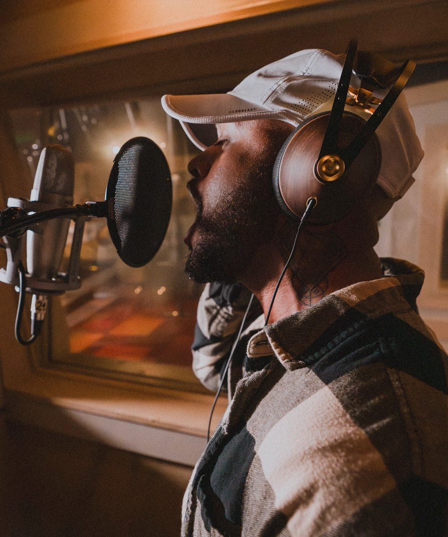 Man in the studio recording vocals using his Meze Audio 99 Classics audiophile premium closed back headphones